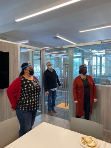 3 co-workers standing at a distance with cards strapped to their heads