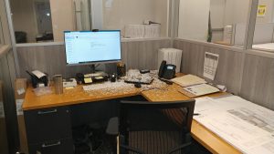 Mike's desk seen with white confetti from the hole-puncher littered all over his keyboard etc.